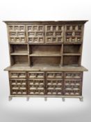 A stained pine kitchen dresser fitted with cupboards and shelves,