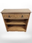 A contemporary oak effect low bookcase fitted with drawers,