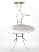 A painted metal three tier circular garden table,