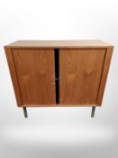 A Danish teak sliding door storage cabinet on raised legs,