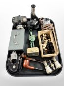 A tray of collectibles, hand cuffs, microscope, mother of pearl mounted opera glasses, pipes,