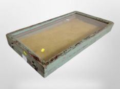 A glazed display cabinet with distressed painted frame,