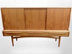 A 1970's teak sliding door sideboard on tapered legs,