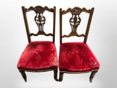 A pair of late Victorian carved salon armchairs in red velvet