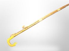 Two vintage wooden walking staffs, and a further walking stick.