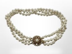 A triple strand of faux pearls