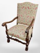 A carved oak framed armchair in Arts and Crafts style upholstery,