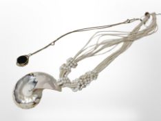 An ammonite pendant on chain and a further compass pendant on chain