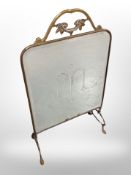 A mirrored brass fire screen,