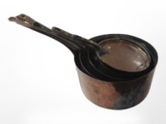 Four graduated Victorian copper saucepans
