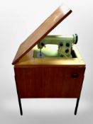 A Husquvarna electric sewing machine in teak cabinet (continental wiring)