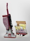 A Kirby upright vacuum cleaner and box of accessories.