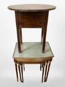A nest of three tables with tool leather inset tops and a further oak oval table