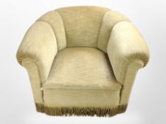 An early 20th century tub armchair in tassel fabric