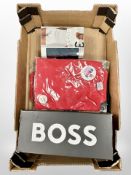 A box of new retail stock items - leather belt, Boss Crew neck shirt, two red polo tops,