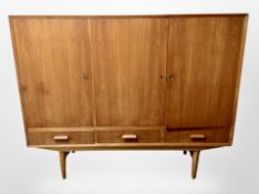 A 1970's teak triple door cocktail sideboard,