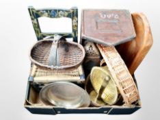 A box of wicker items, wooden bread board, child's chair with rattan seat.