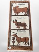 A North African pictorial rug depicting horned cattle and a rhinoceros,