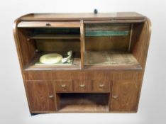 A 1970's Danish teak tambour front entertainment cabinet containing a turntable,