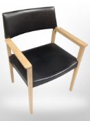 A 20th century oak and black vinyl armchair