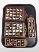 Four wooden thimble display stands containing metal and ceramic thimbles.