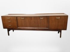 A 1970's teak low sideboard, fitted cupboards and drawers,