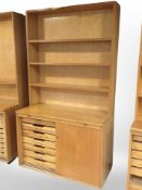 An early 20th century Danish oak and teak sliding door cabinet with compartmentalised interior,