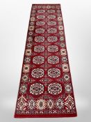 A machine made runner of Afghan Bokhara design,