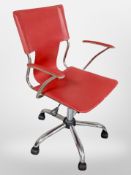 A 20th century chrome framed red vinyl swivel armchair
