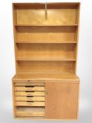 An early 20th century Danish oak and teak sliding door cabinet with compartmentalised interior,