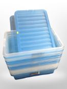 A stack of plastic storage boxes, some with lids.