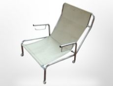 A mid century Danish chrome framed armchair with canvas sling seat raised on castors