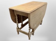 A blond oak barley twist dining table,