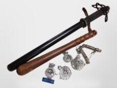 Two wooden police truncheons, a group of badges, two whistles.