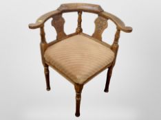 A carved oak corner armchair