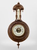A carved walnut barometer.