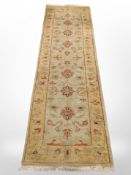 A machine made Persian design runner on green ground,