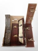 A pair of Eastern hardwood carvings depicting faces and several wooden coat racks.