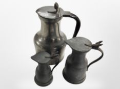 Three graduated pewter jugs, tallest 19cm.