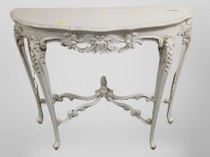 A French carved and cream painted serpentine front console table,