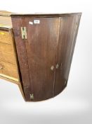 A George III oak double door hanging corner cabinet,