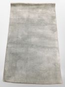 A contemporary machine-made rug on green ground, 140cm x 82cm.