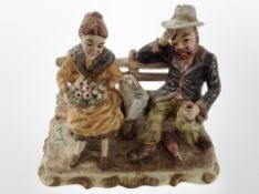 A Capodimonte figure of a lady and gentleman seated on a bench, height 27cm.