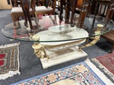 A contemporary classical style oval glass topped coffee table,