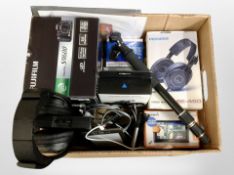 A group of electronics including Pioneer and Sony headphones, Fujifilm camera, Garmin SatNav,
