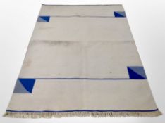 A flat weave rug on cream ground,