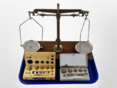 A set of scales on mahogany plinth and two sets of weights in boxes.