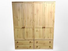 A pair of pine effect double door wardrobes,