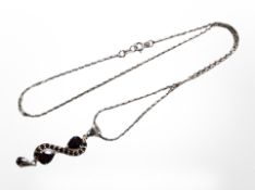 A silver three-part pendant with red faceted stones on segmented chain.