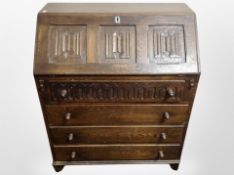An oak linen fold fall front bureau,